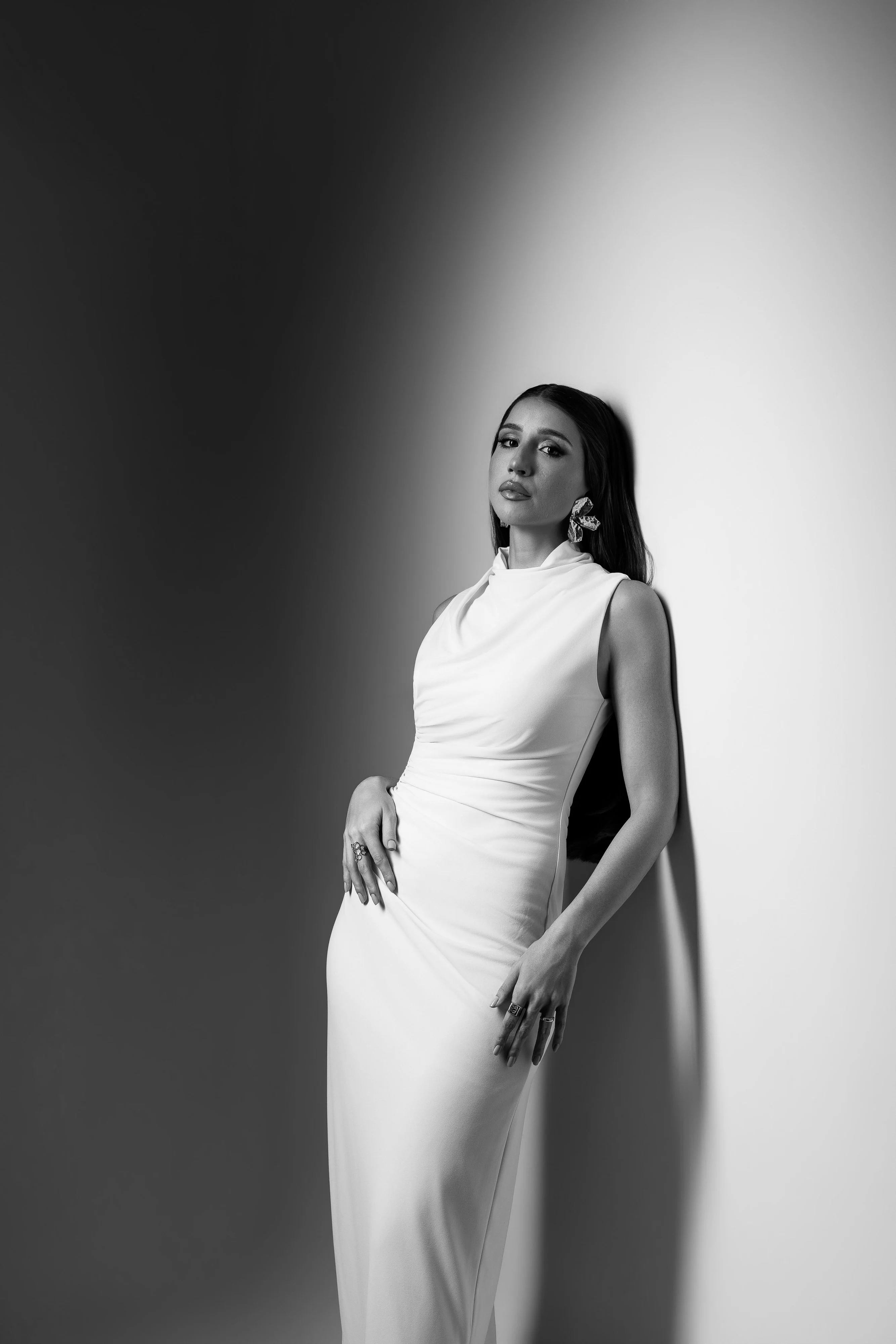 Mulher de vestido longo e cabelo liso em retrato preto e branco com luz lateral