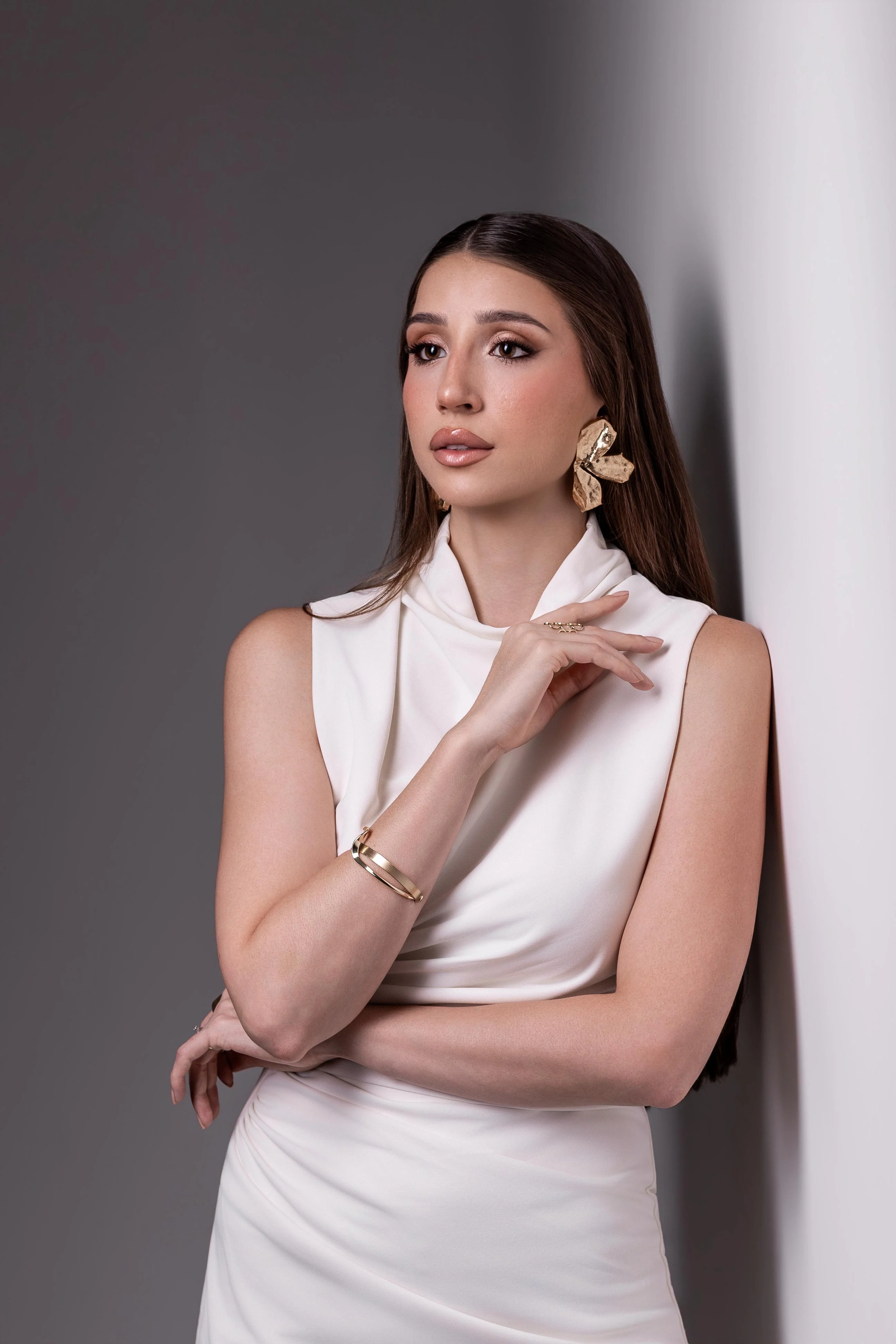 Maquiagem com olhos definidos e cabelo liso em mulher de vestido branco